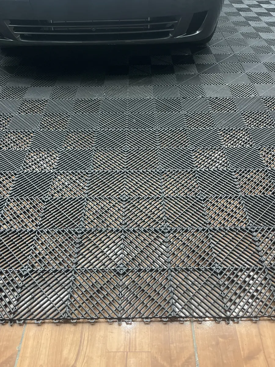 Garagem com piso modular preto e carro estacionado