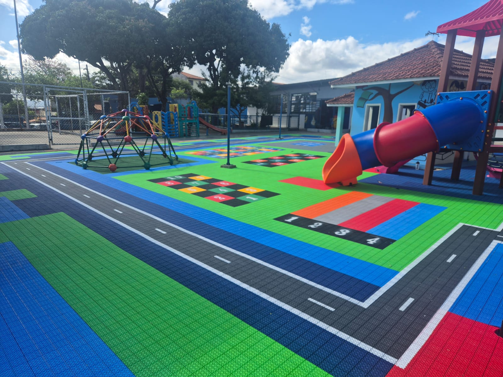Playground infantil colorido com piso modular e painéis educativos