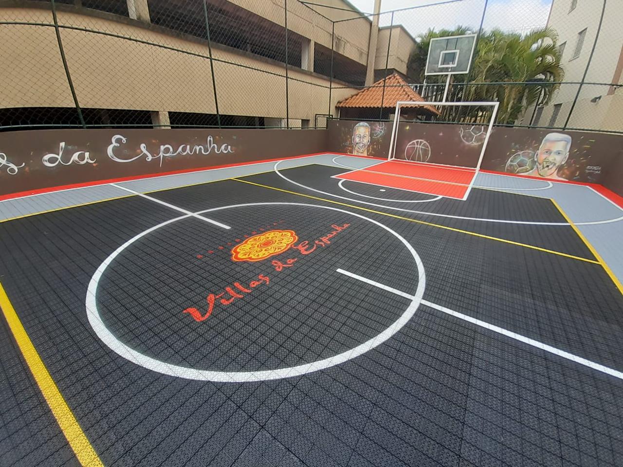 Quadra com piso modular preto e demarcações brancas e amarelas